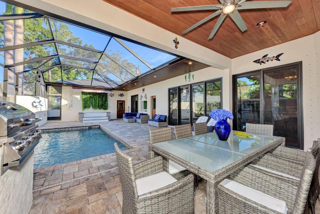 a patio with a table and chairs and a swimming pool at Courtyard Home with Pool, Spa & Sauna close to Beach & City Center in Sarasota