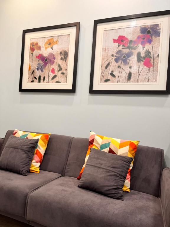 a couch with two pillows in a living room with two pictures at Private Apartment/Suite in Whitby