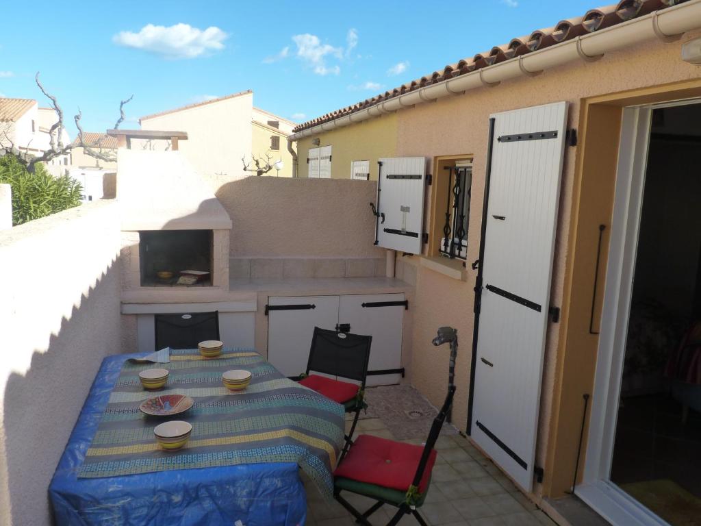 un patio avec une table et des chaises sur un balcon dans l'établissement Coquet Pavillon T2 mezzanine, Les Feulouques, Saint Pierre la Mer, à Saint Pierre La Mer
