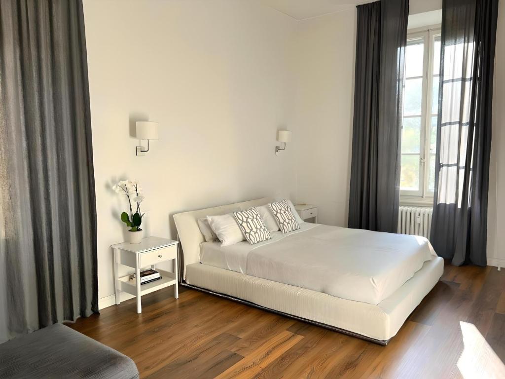 Santa Rosa Florence Apartments 3 Bedrooms - Private Parking في فلورنسا: غرفة نوم بيضاء بها سرير ونافذة