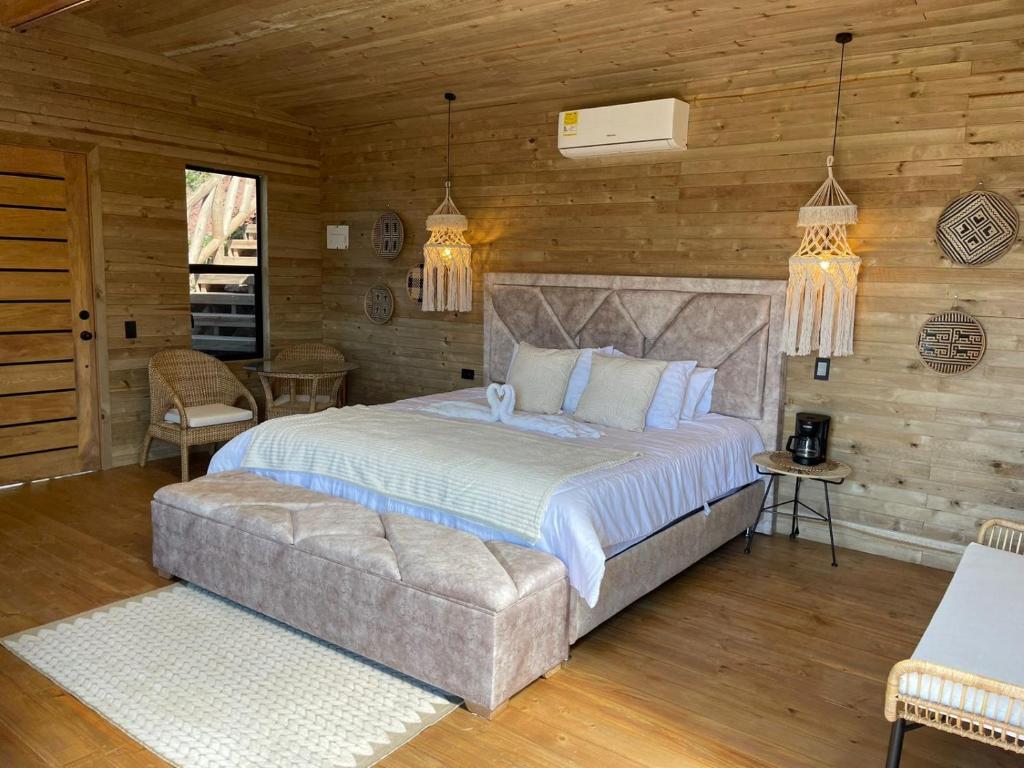 聖赫羅尼莫的住宿－Nalua Glamping y Hotel，一间卧室配有一张大床和一张沙发