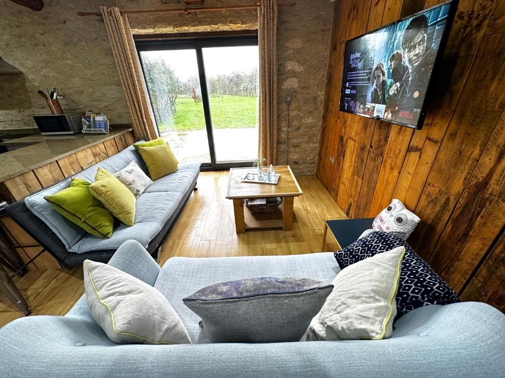 uma sala de estar com dois sofás e uma mesa em Dove House Cottages - No 2 em Witney