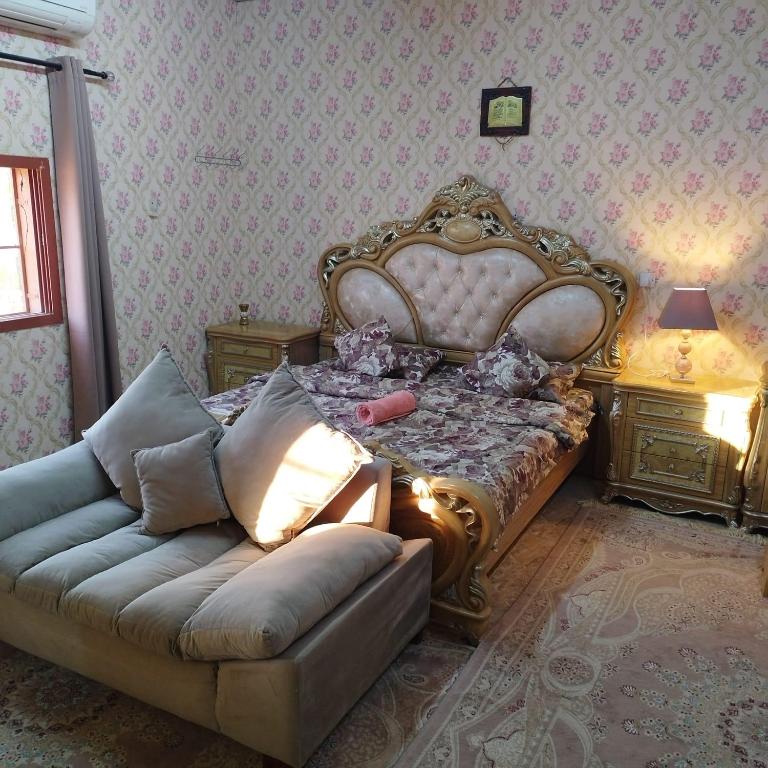 1 dormitorio con 1 cama, 1 sofá y 1 lámpara en العين الهيلي مصباح بيت 11, en Al Ain