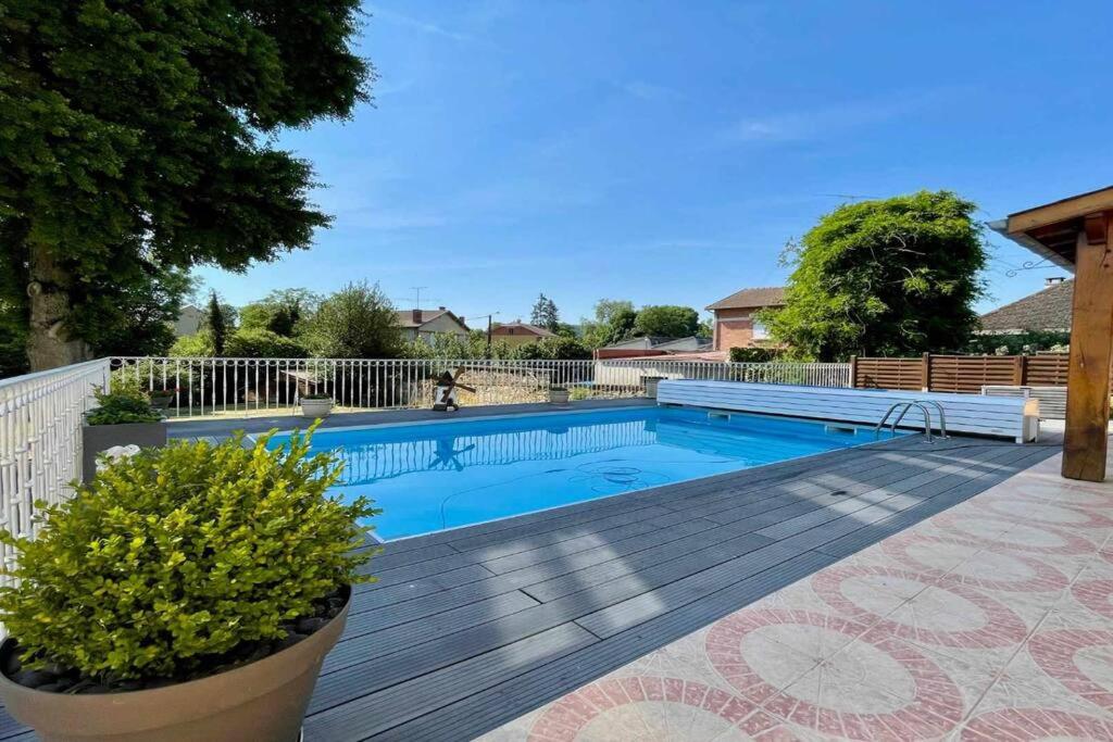 a swimming pool in a yard with a wooden deck at Gîte des 40 écus - Maison de maître 10 personnes in Grandpré
