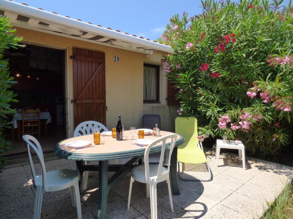 une table et des chaises assises sur une terrasse dans l'établissement Pavillon Studio Mezzanine, Les Patios de la Plage, Saint Pierre la Mer, à Saint Pierre La Mer