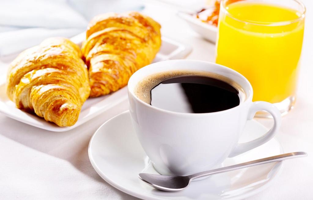 Una taza de café y pasteles en una mesa. en NiceShortStayMassena, en Massena