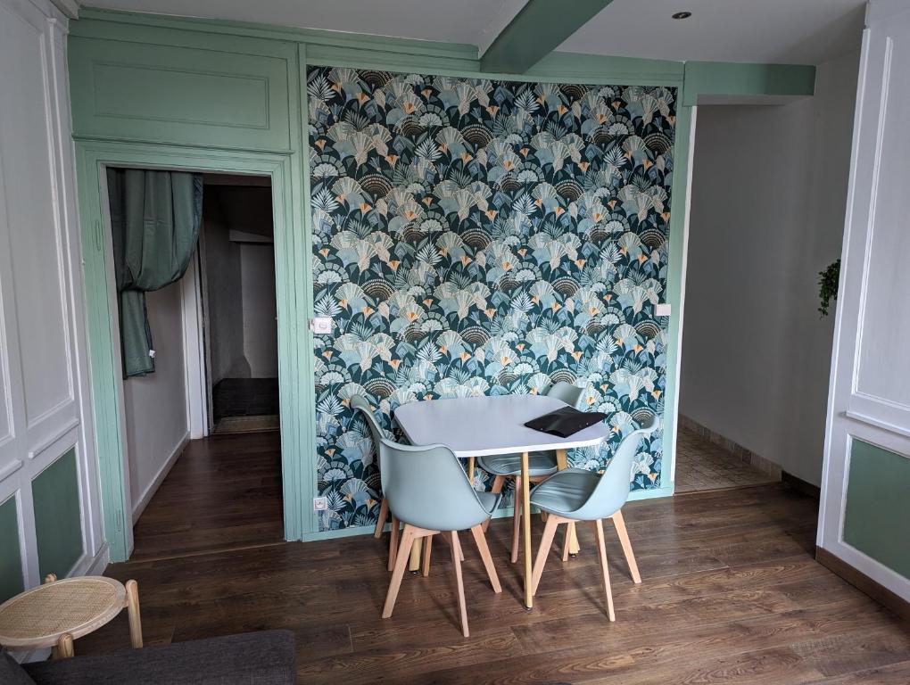 a table and chairs in a room with a wallpaper at Le Saint Leonard... Il est Vert in Honfleur