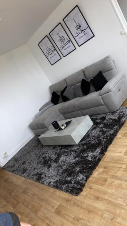 a living room with a couch and a table at Appartement proche aéroport Beauvais-tille in Beauvais