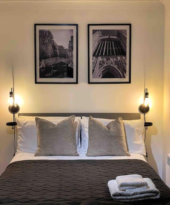 um quarto com uma cama com três fotografias na parede em Cozy studio near train station em Cambridge