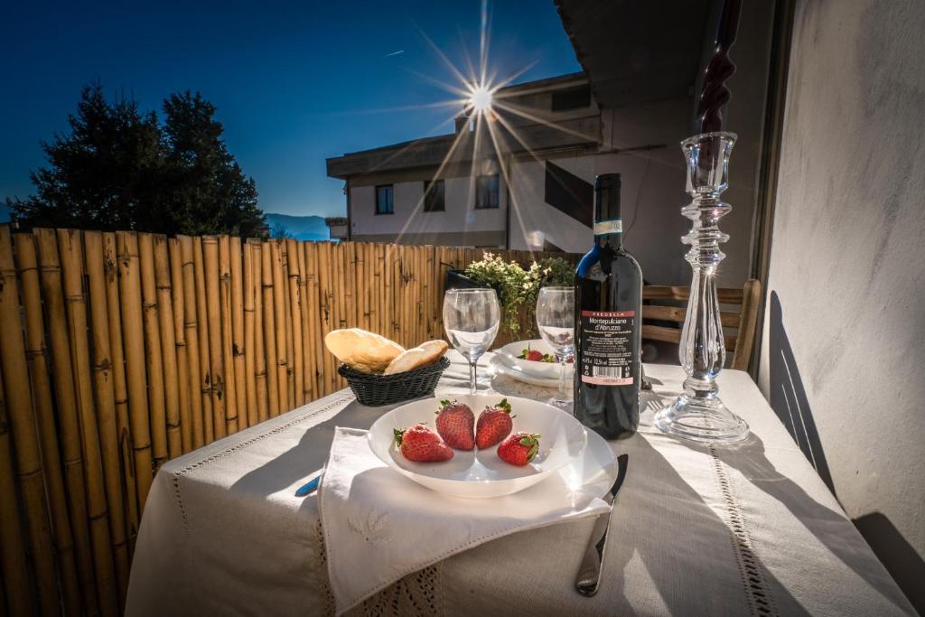 una mesa con una botella de vino y fresas. en La casa di Lucca - terrace and parking, en Lucca