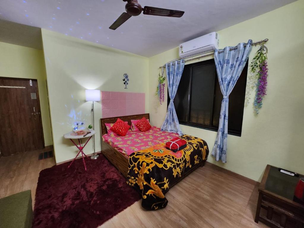 a bedroom with a bed with red pillows and a window at Bhumi Holiday Home in Alibaug