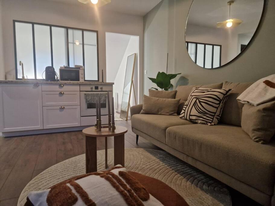 un salon avec un canapé et un miroir dans l'établissement Appartement Cosy Centre-Ville, à Angers