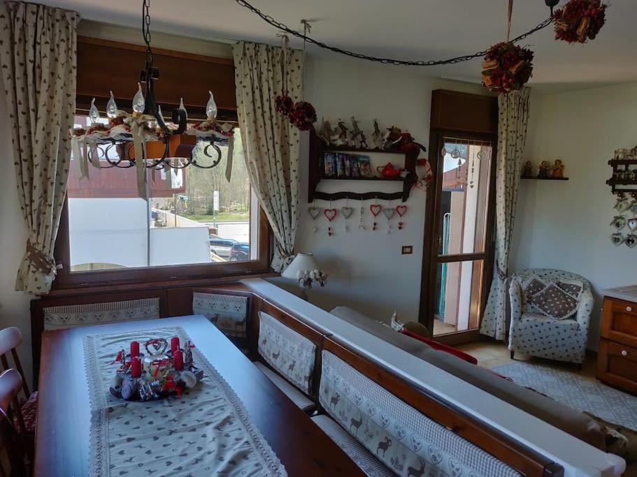 um quarto com uma cama, uma mesa e uma janela em Appartamento comodo e curato per famiglie em Pieve di Cadore