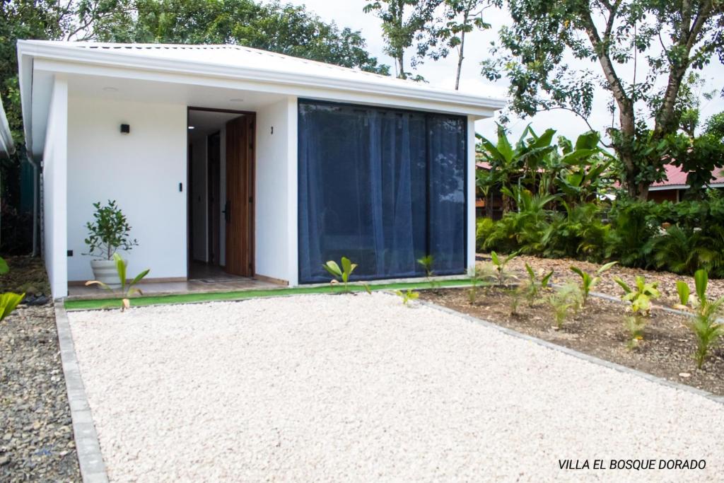 une maison blanche avec une grande porte en verre dans l'établissement Villa El Bosque Dorado, à Fortuna