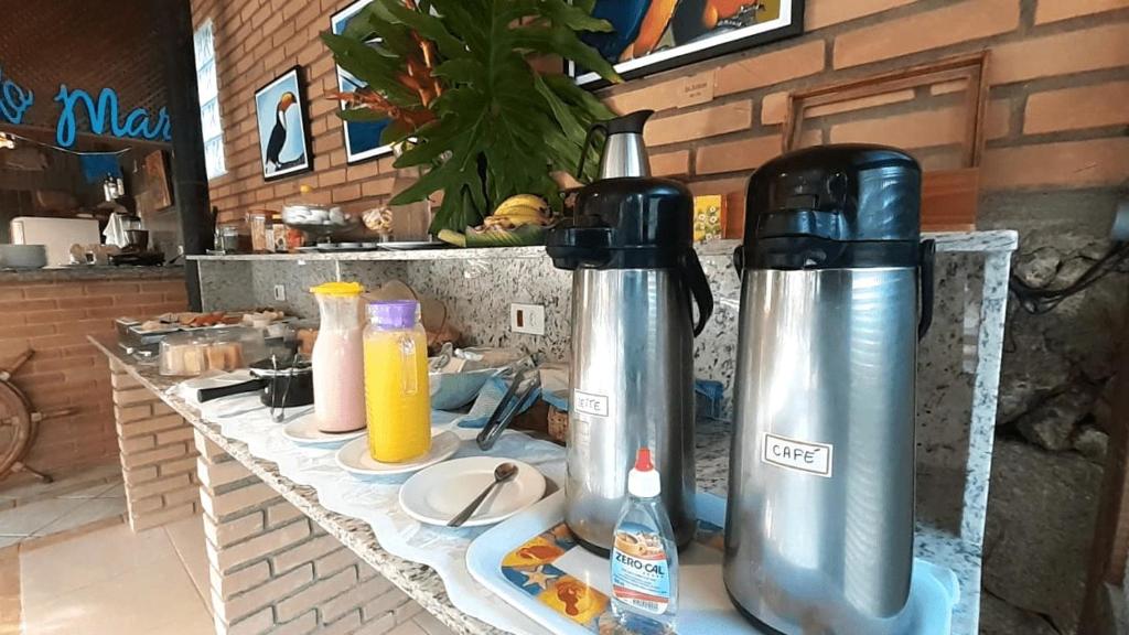 - deux bouteilles d'eau assises sur un comptoir dans une cuisine dans l'établissement Pousada e SPA Canto do Mar, à Guarujá