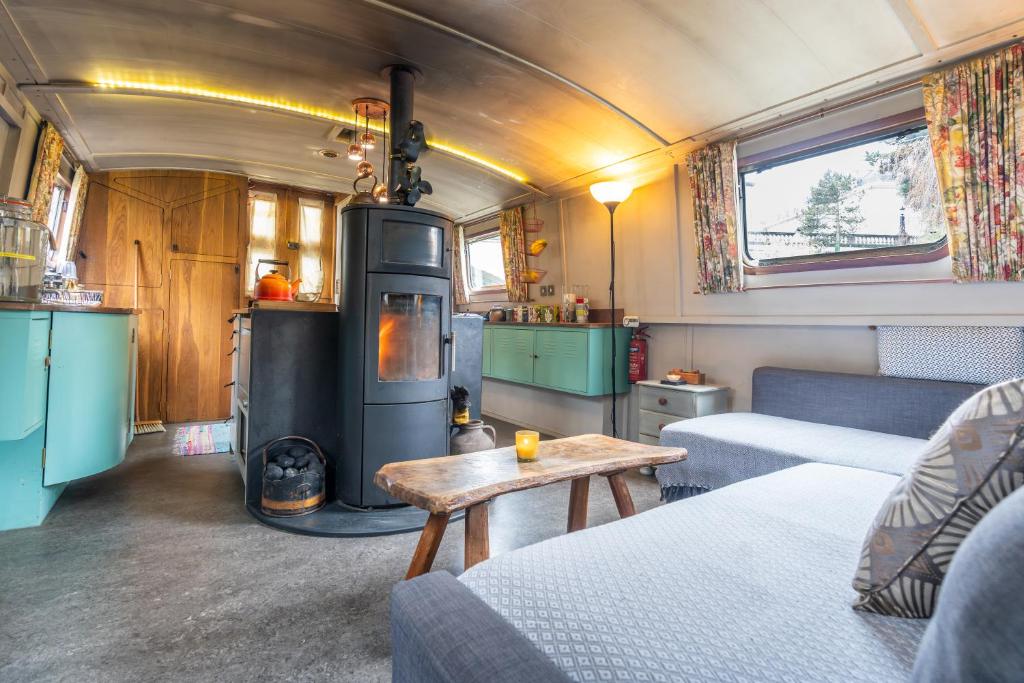 a living room with a stove in a tiny house at Off-Grid Living on Spacious Widebeam in Bath