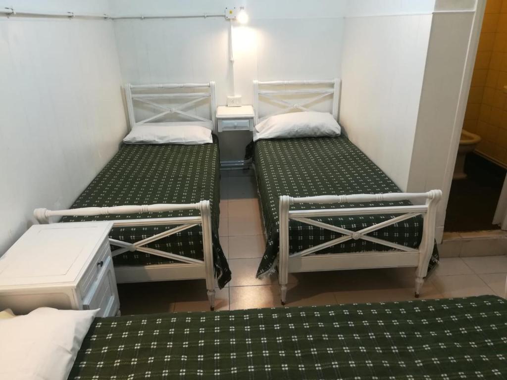 2 camas en una habitación con verde y blanco en Hotel Ciudad Feliz en Mar del Plata