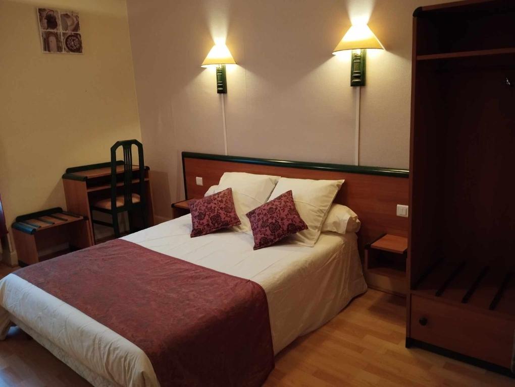 1 dormitorio con 1 cama con 2 almohadas en Hôtel Moderne, en Prades-dʼAubrac