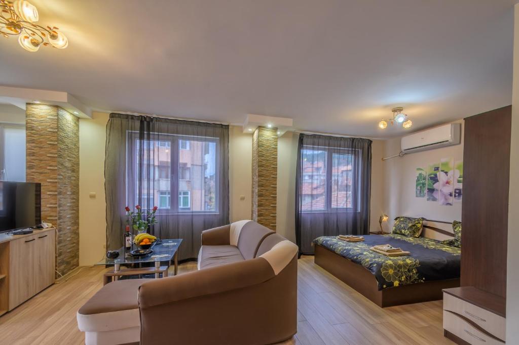 1 dormitorio con cama, sofá y mesa en Cozy & Delightful Apart & AUBG & Free Garage Parking en Blagoevgrad