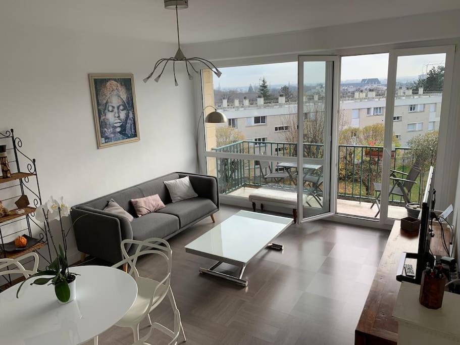 un salon avec un canapé et une table dans l'établissement Appartement de charme, 76 m2, Quartier St GABRIEL, à Caen