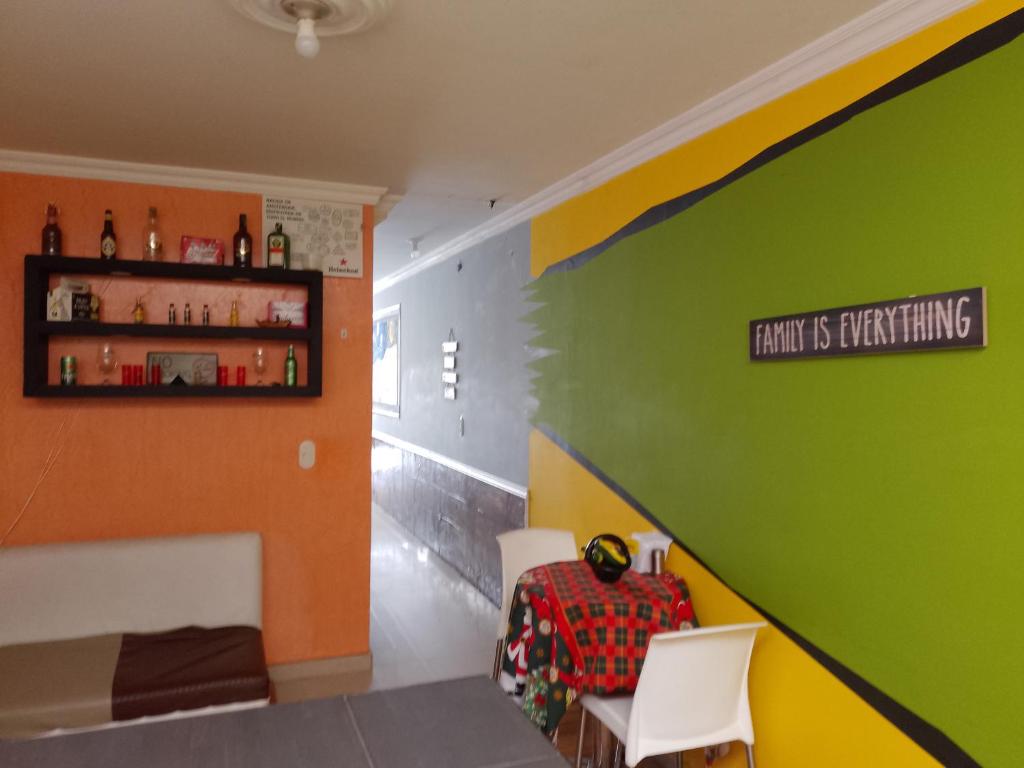 波哥大的住宿－Universo Turístico Bogotá，一间拥有绿色和橙色墙壁的客房,配有架子
