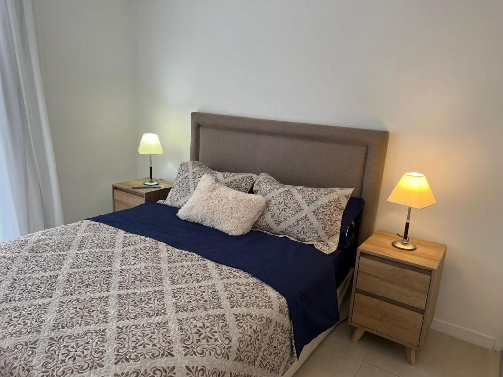 um quarto com uma cama com 2 candeeiros nas mesas em Confortable departamento en Castelar - Zona Céntrica. em Castelar