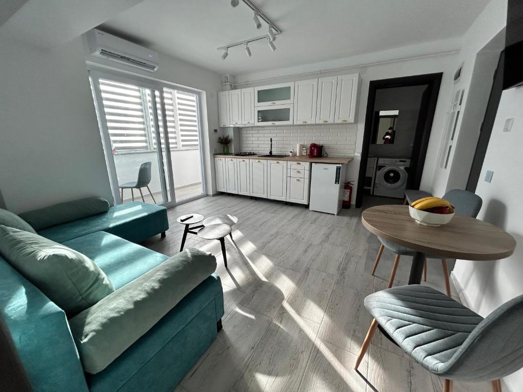 - un salon avec un canapé bleu et une table dans l'établissement 1 Mai - Luxury Park Apartments - Self Check-in - Private parking - 2, à Craiova
