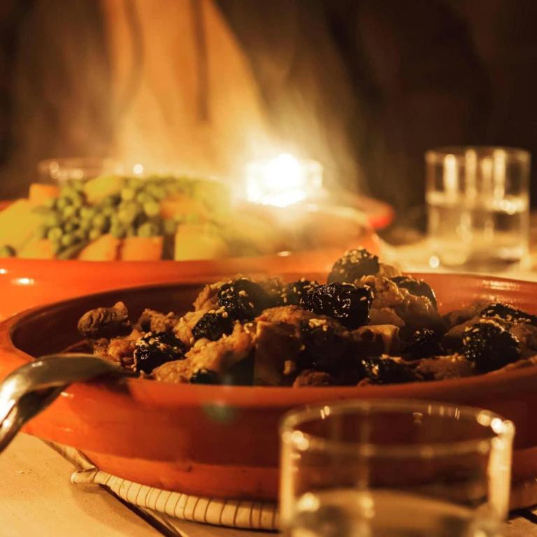 a bowl of food in front of a fire at Merzouga Desert Campsite &Activities in Merzouga