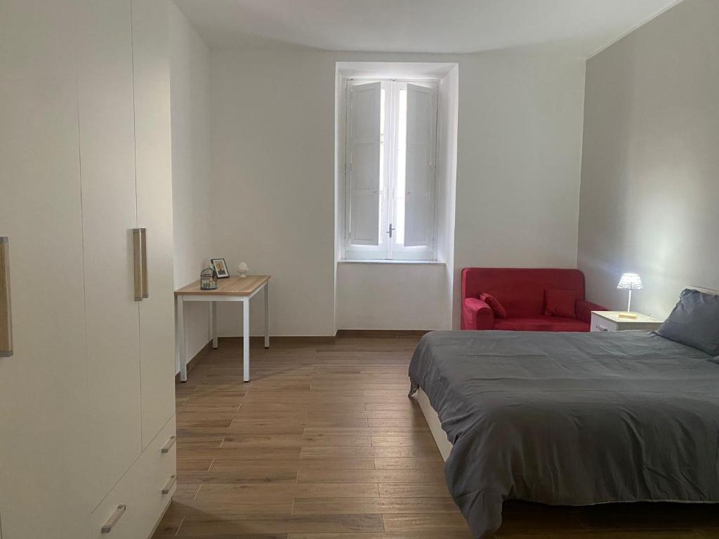 a bedroom with a bed and a red chair at Via Rivocati 108 in Cosenza