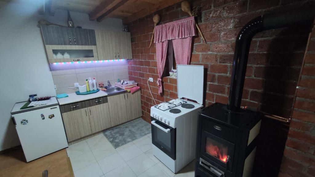 a kitchen with a stove and a brick wall at Vikendica Vrtača- Odvraćenica in Novi Pazar