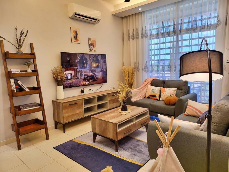 uma sala de estar com um sofá e uma televisão em Sunway Cozy Apartment near Lost World of Tambun em Ipoh