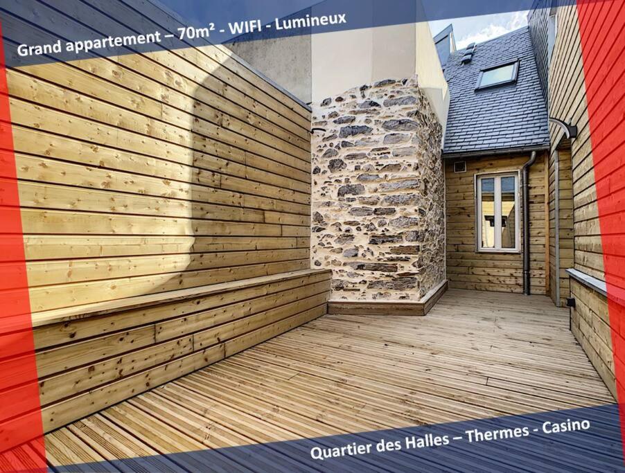 una parete di contenimento in legno accanto a un edificio con terrazza di [L'ABBAT-JOUR] L'émeraude • Plein Sud • Thermes a Bagnères-de-Bigorre