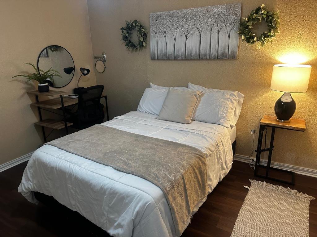 um quarto com uma cama com lençóis brancos e almofadas em Eagle Stay 7 Condo em Eagle Pass
