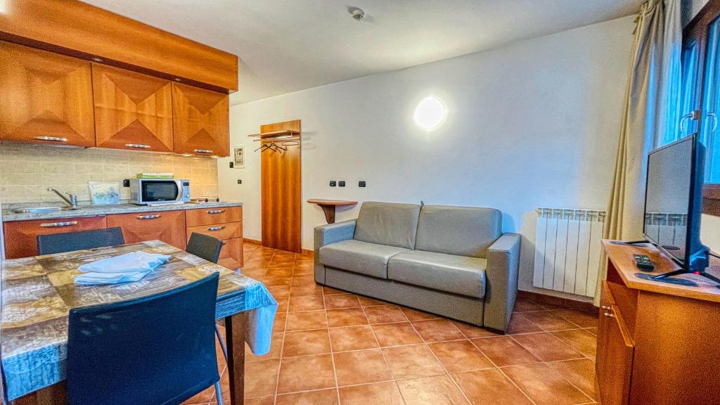 uma cozinha e sala de estar com uma mesa e um sofá em Appartamento Smith Bonarda - Affitti Brevi Italia em Bardonecchia