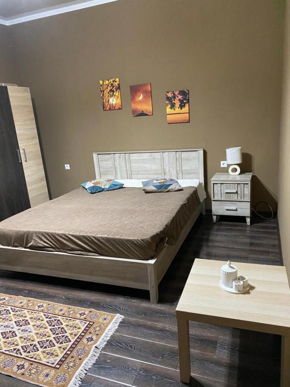 Un dormitorio con una cama y una mesa. en Гостевой дом Александрия, en Gudauta