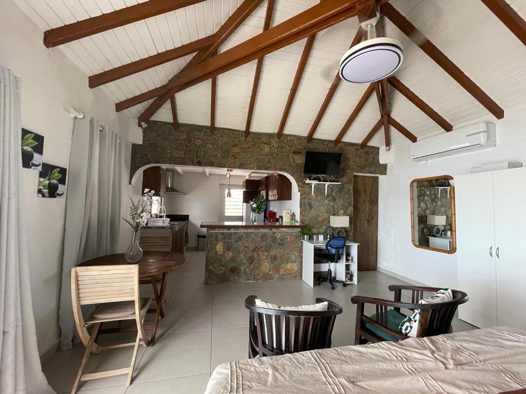 eine Küche und ein Wohnzimmer mit einem Tisch und Stühlen in der Unterkunft Studio Colline Nettle in Marigot