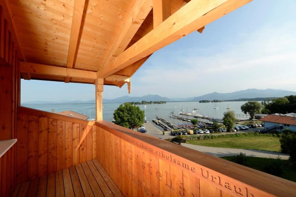 uma varanda de madeira com vista para uma marina em Hotel ChiemseePanorama em Gstadt am Chiemsee