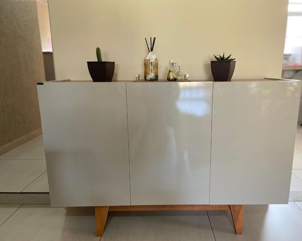 een witte kast met potplanten erop bij Casa ao lado do centro in Itabira