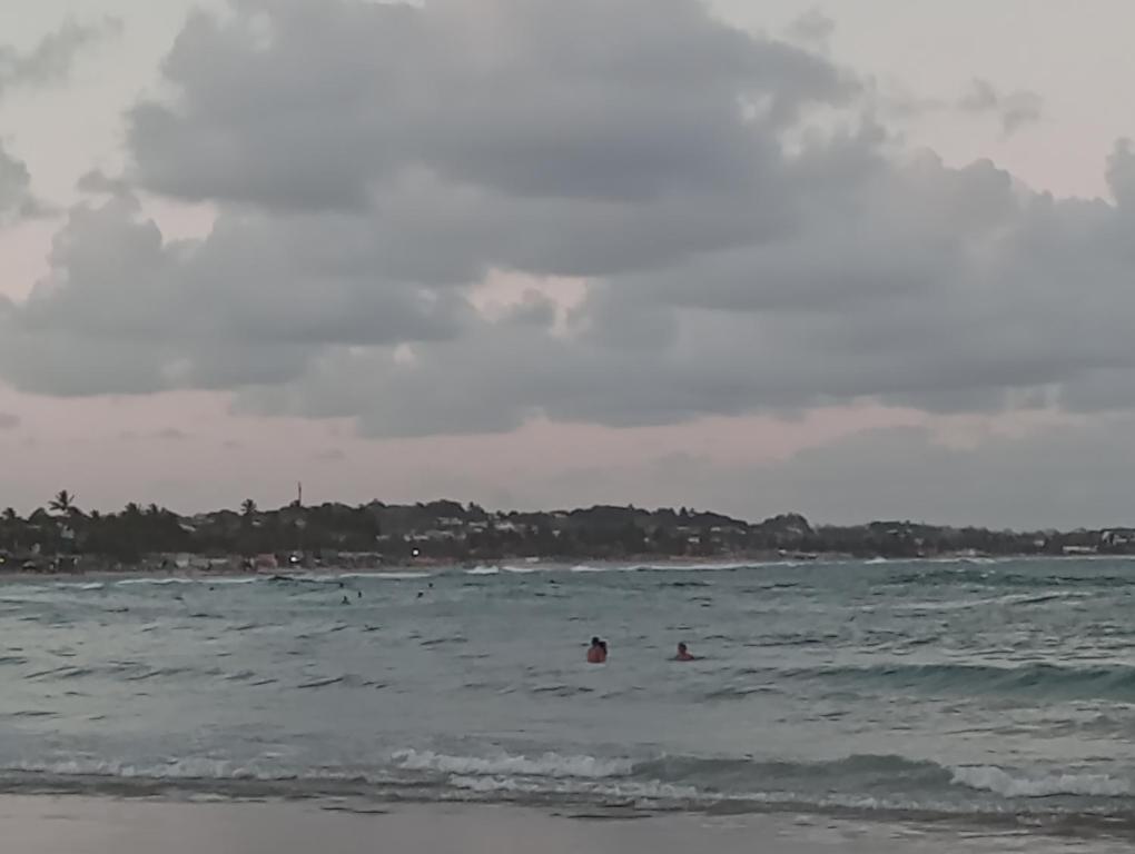 a group of people in the water at the beach at Mar doce lar in Cabo de Santo Agostinho