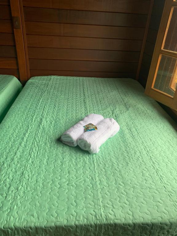 een handdoek op een groen bed bij Recanto Sol Poente in Caçapava