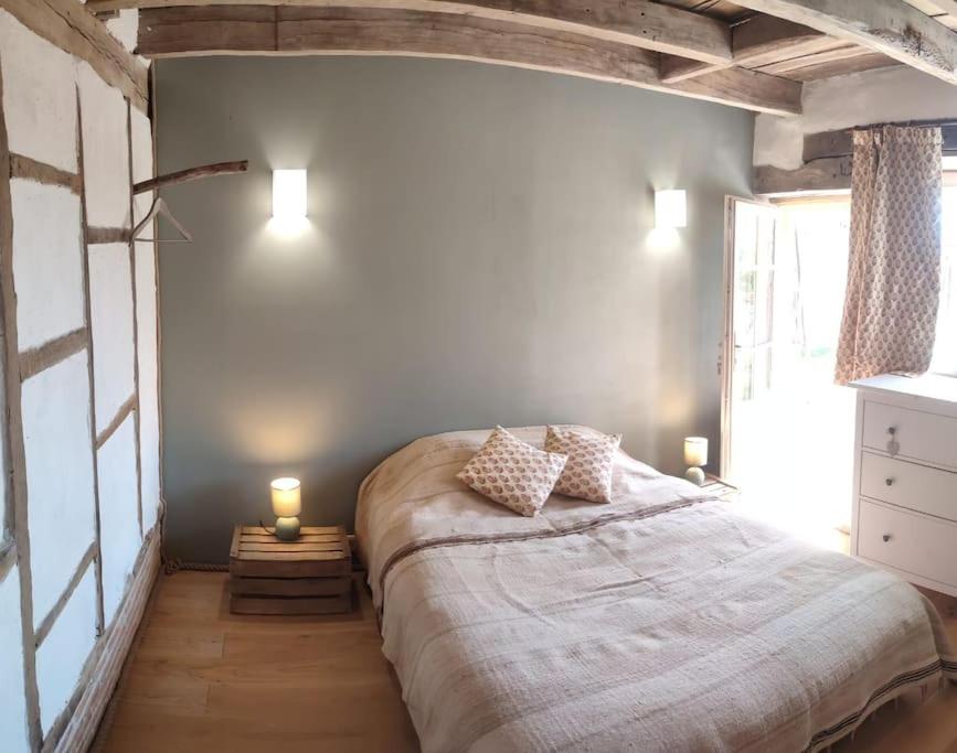 - une chambre dotée d'un grand lit avec deux bougies dans l'établissement Le cottage des Acacias, à Salignac Eyvigues