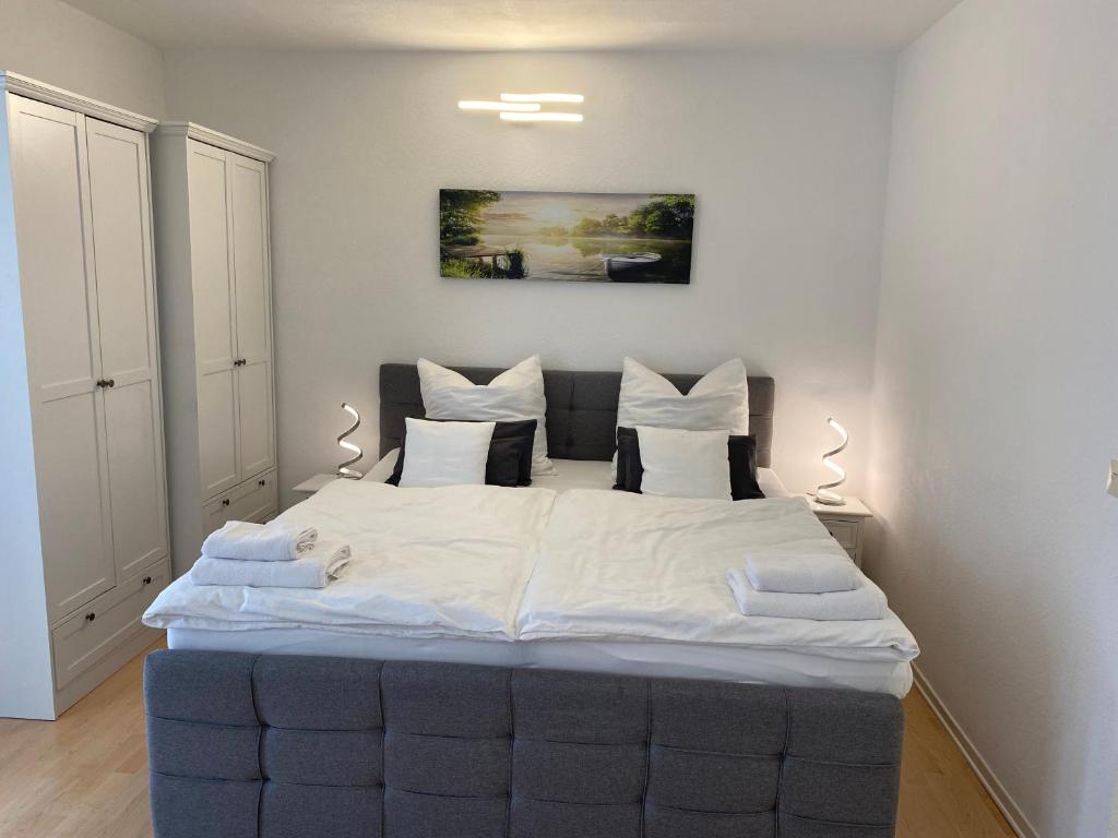 1 dormitorio con 1 cama grande con sábanas blancas en Unterkunft am Steinhuder Meer, en Wunstorf