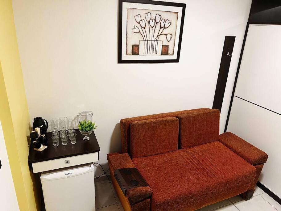 ein Wohnzimmer mit einem braunen Sofa und einem Tisch in der Unterkunft Flat próx. a USP e Nações Unidas in Bauru