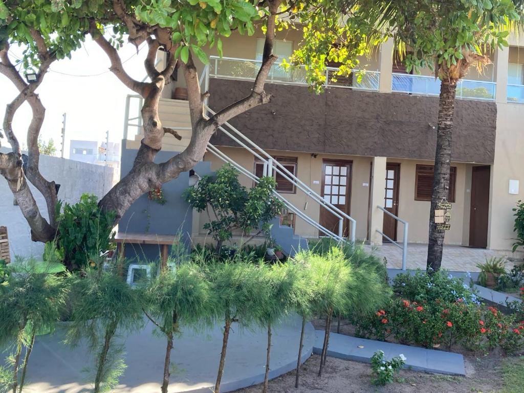 a building with a staircase in the middle of trees at Pousada Vitória in Pitimbu