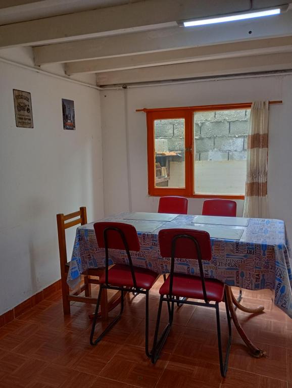 Zimmer mit einem Tisch, Stühlen und einem Fenster in der Unterkunft Alojamiento económico in Ushuaia