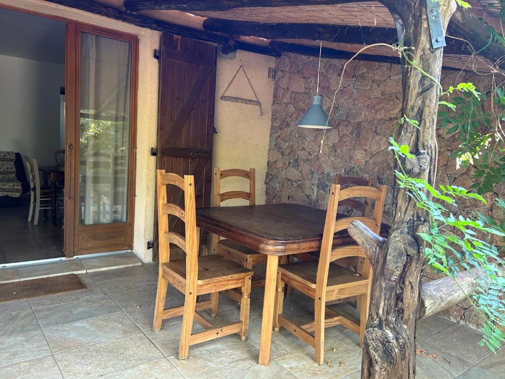 a wooden table and chairs on a patio at A casa di maria in Figari