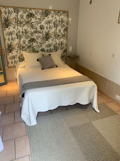 - une chambre avec un lit doté d'une grande tête de lit dans l'établissement Studio décoré avec goût, à Saint-Paul-Trois-Châteaux