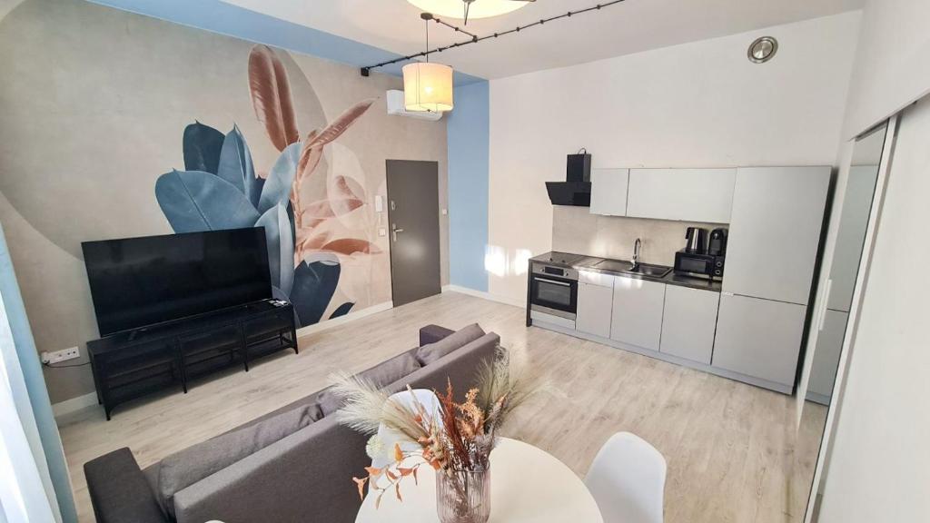 a living room with a couch and a tv and a table at Apartment Quiet Street 11, 3E in Oświęcim