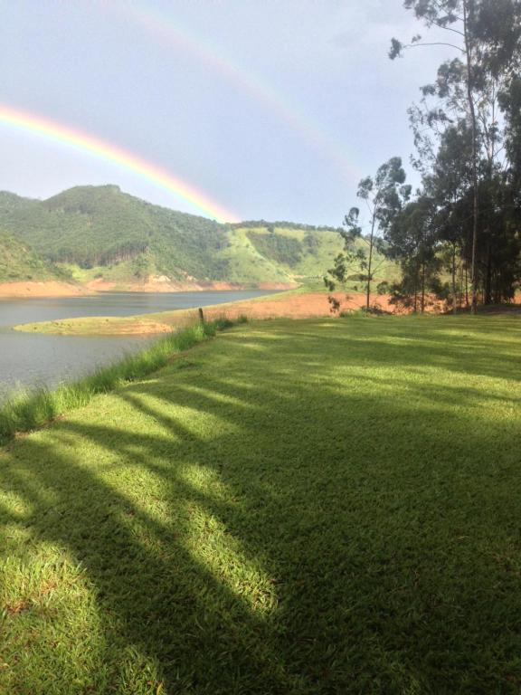 een regenboog over een veld naast een meer bij Casa INTI Refugio Romantico Pague duas noites minimo e a terceira e brinde, menos feriados in Natividade da Serra
