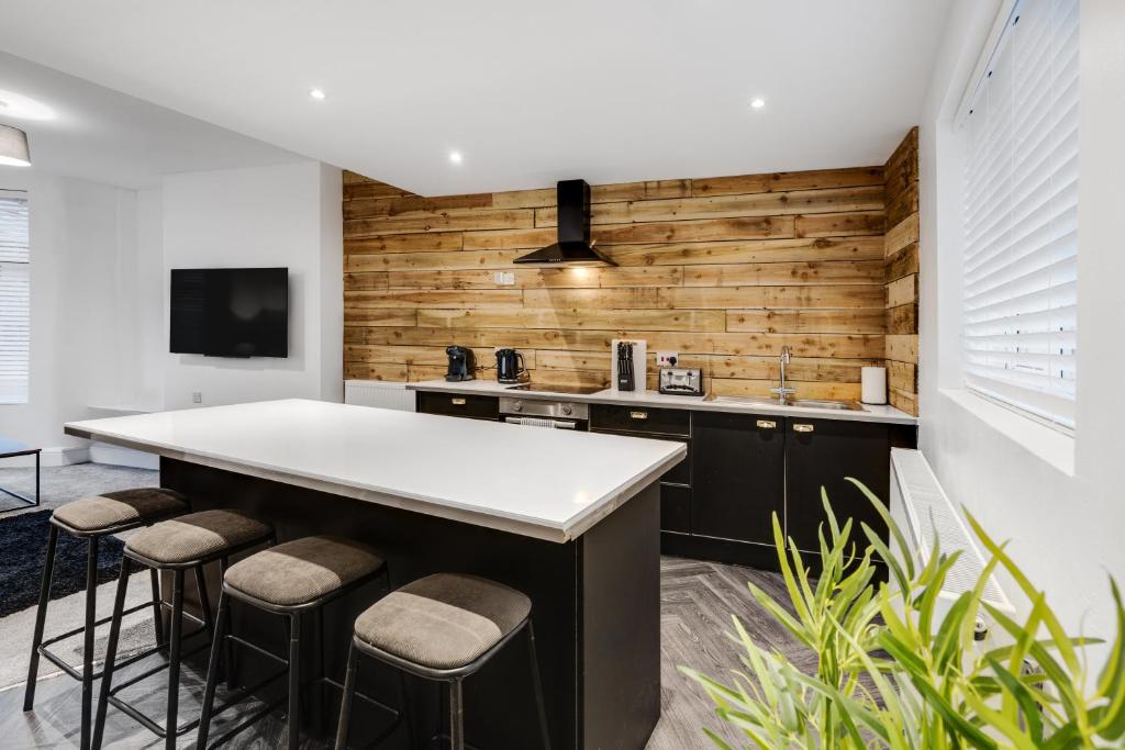 a kitchen with a large island with bar stools at Harrow Lodge - Anfield Apartments in Liverpool